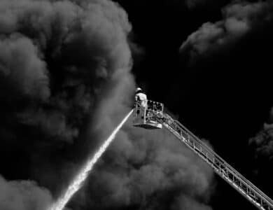 Firefighter on a Crane Extinguishing a Large Fire