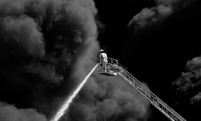 Firefighter on a Crane Extinguishing a Large Fire