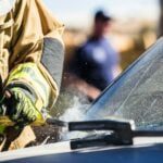 a man in a fireman's uniform sanding a car