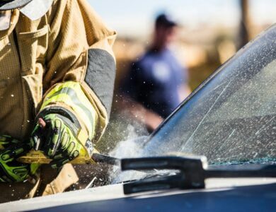 a man in a fireman's uniform sanding a car