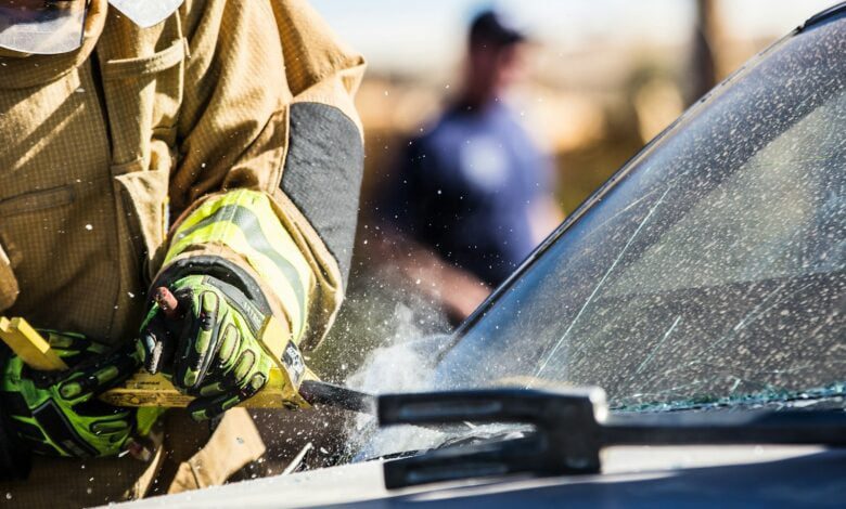 a man in a fireman's uniform sanding a car