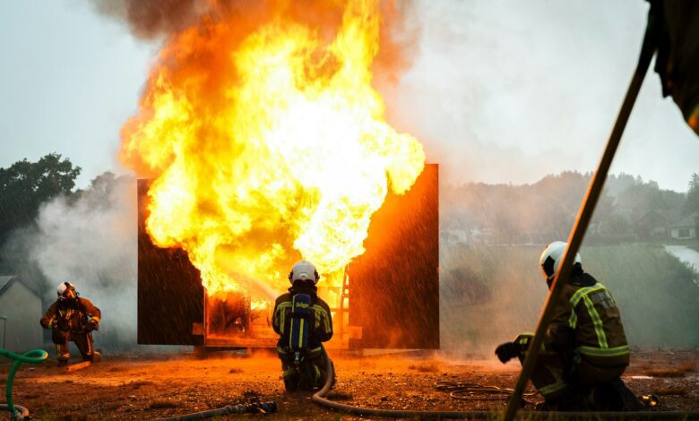a group of fire fighters standing around a fire